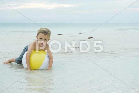 Little Boy Lying On Beach Ball, Smiling At Camera, Full Length