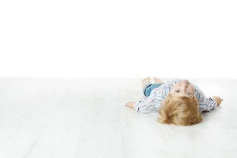 Little boy lying down on floor and looking at camera Stock Photos