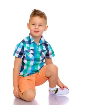 A little boy is lying on the floor in the studio. Stock Photos