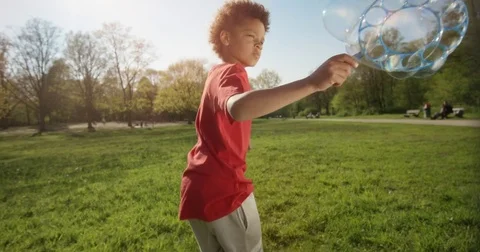 Little Boy is making big bubbles while running . Video stock 78161305