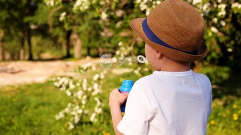 Little boy is making bubbles in the sunshine Stock Footage 89861272