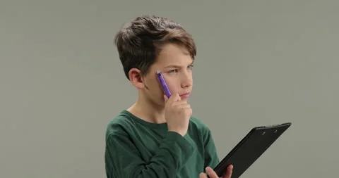 Little boy making notes, writing down ideas, thoughts with pen into notepad Stock Footage 261589275