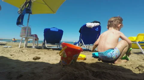 Little Boy Making a Sandcastle on the Beach on a Summer Day Stock Footage 61349989