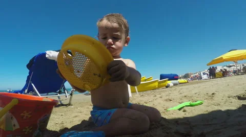Little Boy Making a Sandcastle on the Beach on a Summer Day Stock Footage 61351153
