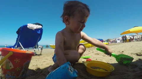 Little Boy Making a Sandcastle on the Beach on a Summer Day Stockbeeldmateriaal 61355041