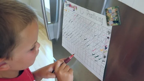 A little boy marks off another day on happy practicing chart Stock Footage 91407159