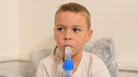 Little boy with nebulizer inhaler machine for inhalation Stock Footage 121586202