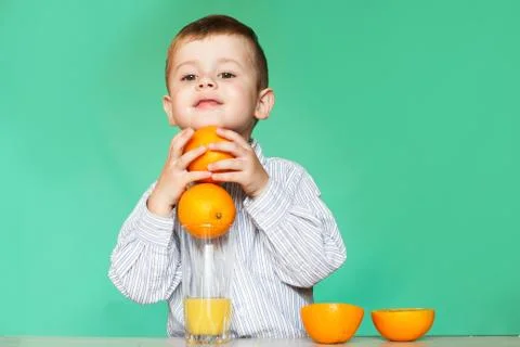 Little boy with oranges and juice. Happy little boy drinking orange juice on Stock Photos