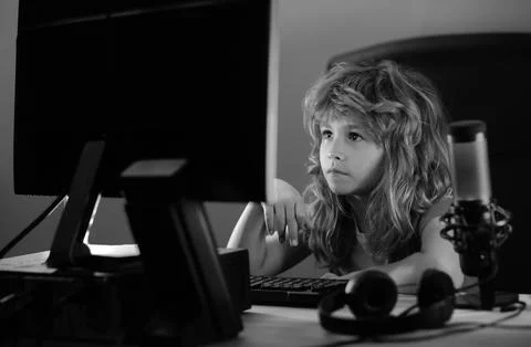 Little boy at the pc computer screen. Cute preschool kid is watching movie by Stock Photos