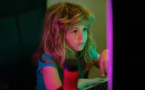 Little boy at the pc computer screen. A pretty child learns a lesson using a Stock Photos