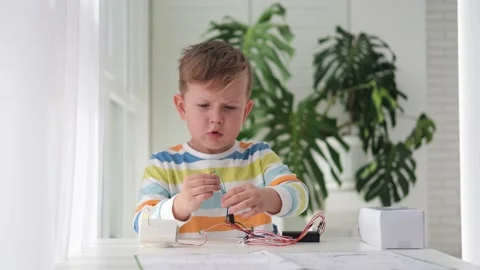 Little boy performing or studying science with wires, connections. Stock Footage 187471909