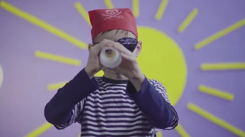Little boy pirate using monocular, sun decoration in background, kid acting, 4k. Stock Footage 104168592