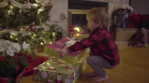 Little Boy Places A Large Present Under Christmas Tree, Sister Adds More To Pile Stock Footage 67357628