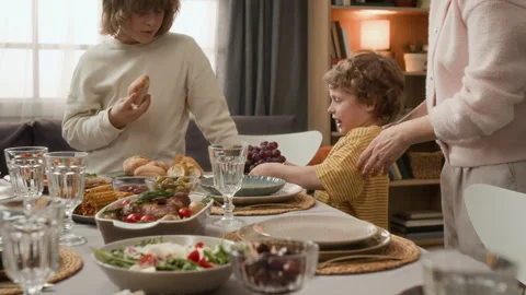 Little Boy Placing Fruit Plate on Family Dinner Table with Mother Stock Footage 340336597
