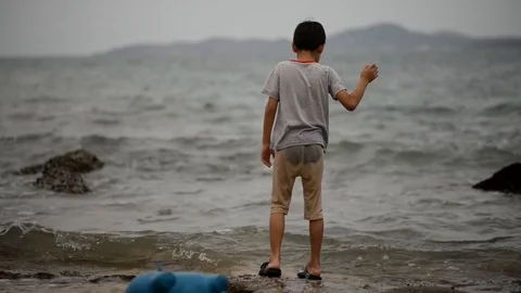 Little boy playing alone on the beach Stockbeeldmateriaal 73922997