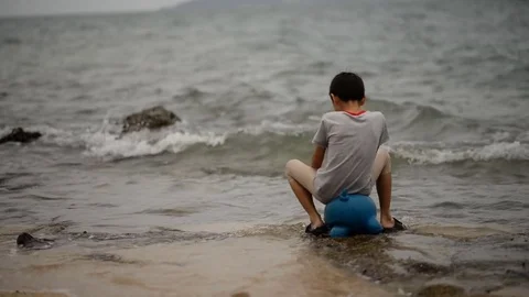 Little boy playing alone on the beach Stockbeeldmateriaal 73923075