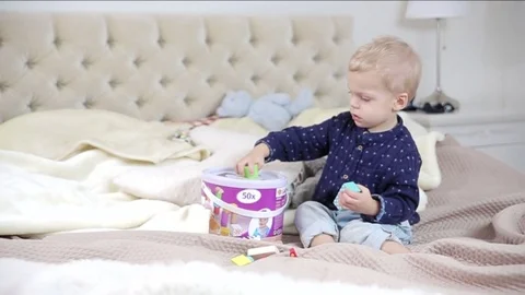 Little boy is playing with blocks on a bad.FULL HD.tracking shot Stock Footage 73968137
