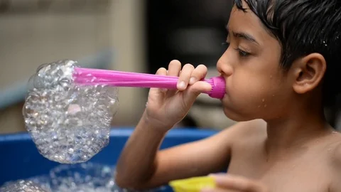 Little boy playing bubble showing water splash Stockbeeldmateriaal 75441657