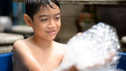 Little boy playing bubble showing water splash Stockbeeldmateriaal 75441758