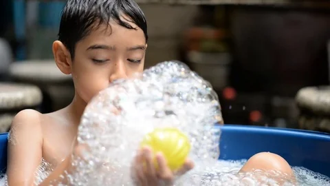 Little boy playing bubble showing water splash Stockbeeldmateriaal 75442099