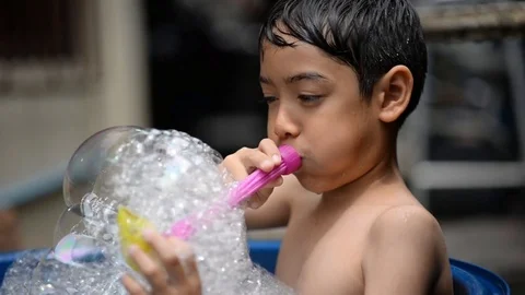 Little boy playing bubble showing water splash Stockbeeldmateriaal 75442192