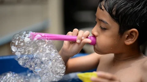 Little boy playing bubble showing water splash Stockbeeldmateriaal 75442404