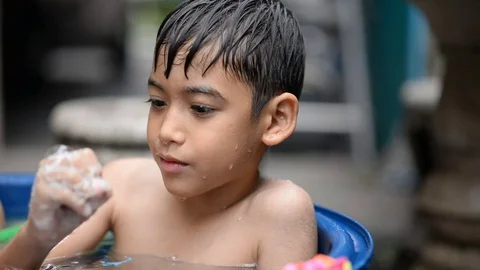 Little boy playing bubble showing water splash Stockbeeldmateriaal 75442431