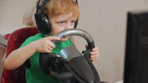 Little Boy Playing On Car Simulator Stock Footage 168884008