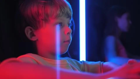 A little boy is playing computer games in a computer club in the dark. Stock Footage 287579822