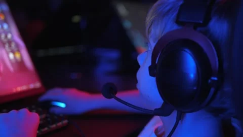 A little boy is playing computer games in a modern computer club in the dark. Stock Footage 331696556
