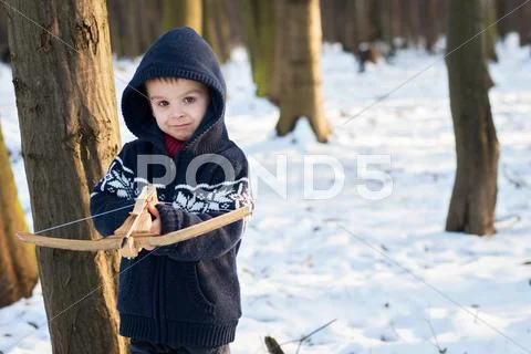 Little boy, playing with crossbow in the park Stock Photos