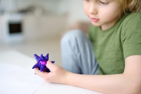Little boy playing dough at home during coronavirus quarantine. Child is mold Foto stock