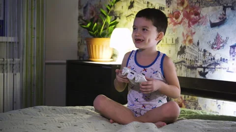 A little boy is playing a game console Stock Footage 169148498