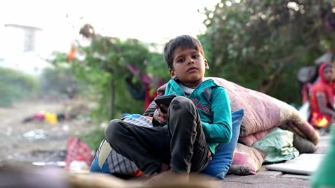 Little boy playing game on mobile and looking at the camera Stock Footage 268946292