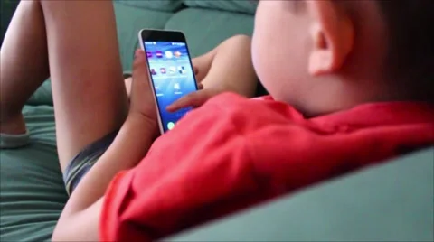 Little Boy playing games on your mobile phone Stock Footage 65301018