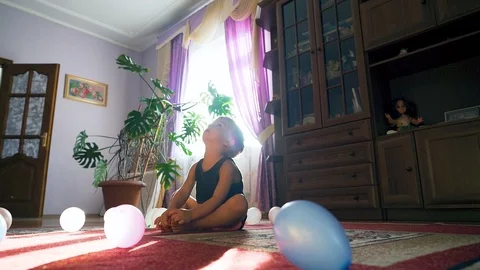 Little boy playing with a lot of multicolored baloons, slow motion. Indoor Stock Footage 107841777