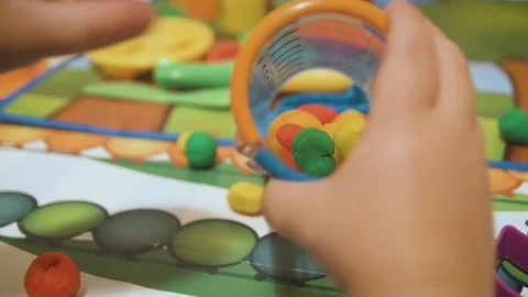 Little boy playing with modeling dough in his room Stock Footage 98800560