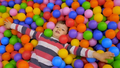 Little boy playing in the pool with plastic balls in the nursery. The kid is Stock Footage 104317321