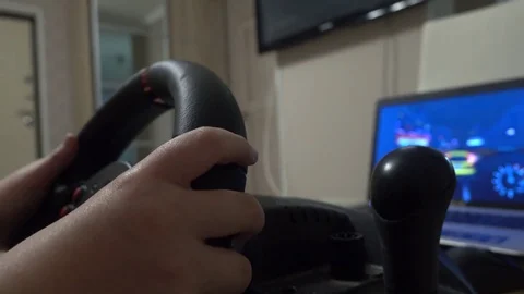Little boy playing racing computer game using steering wheel Stock Footage 73285722
