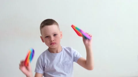 Little boy playing with rainbow popit at home. Modern silicone toy, trend 2021 Stock Footage 156844976