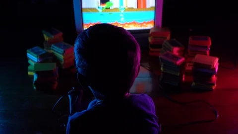 Little boy playing in retro console. Neon lighting.A view from the shoulders Stock Footage 126204172
