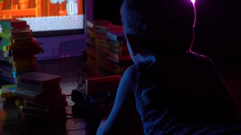 Little boy playing in retro console, view from behind shoulders. Neon lighting Stock Footage 126204696