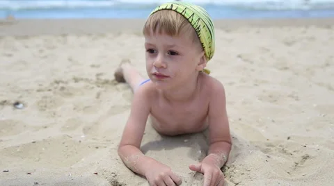 Little boy playing with sand on the beach Stock Footage 52822950
