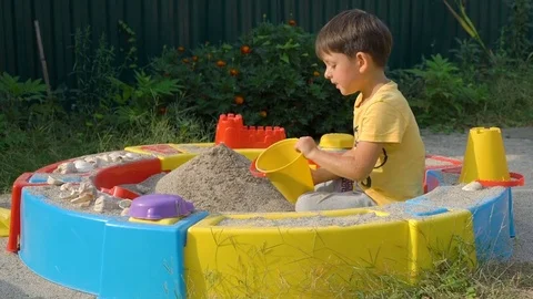 Little boy playing with sand in a sandbox Stock Footage 80727053