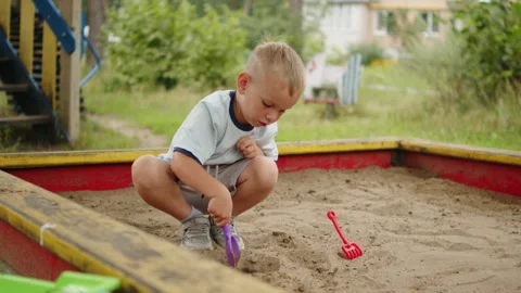 Little boy playing in a sandbox. Small blonde child in a wooden sandbox, di.. Stock-Footage 341270580