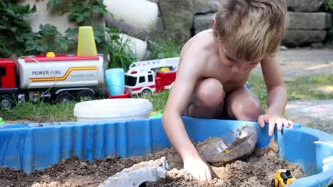Little boy playing in a small sandbox in the backyard Stock Footage 341436482