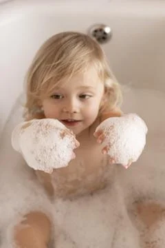 Little boy playing with soap bubbles in bathtub Stock Photos