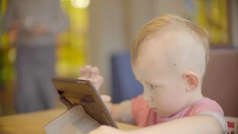 Little boy playing on the tablet and waiter bringing ice-cream Stock Footage 72673541
