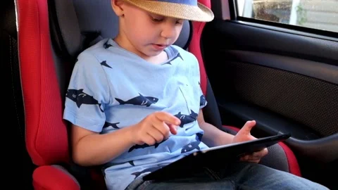 Little boy Playing with Tablet in the car Stock Footage 89516867