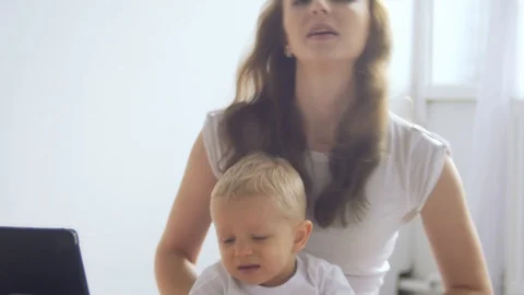 Little boy playing on the tablet computer games, his mother disguises him Stock Footage 87247511